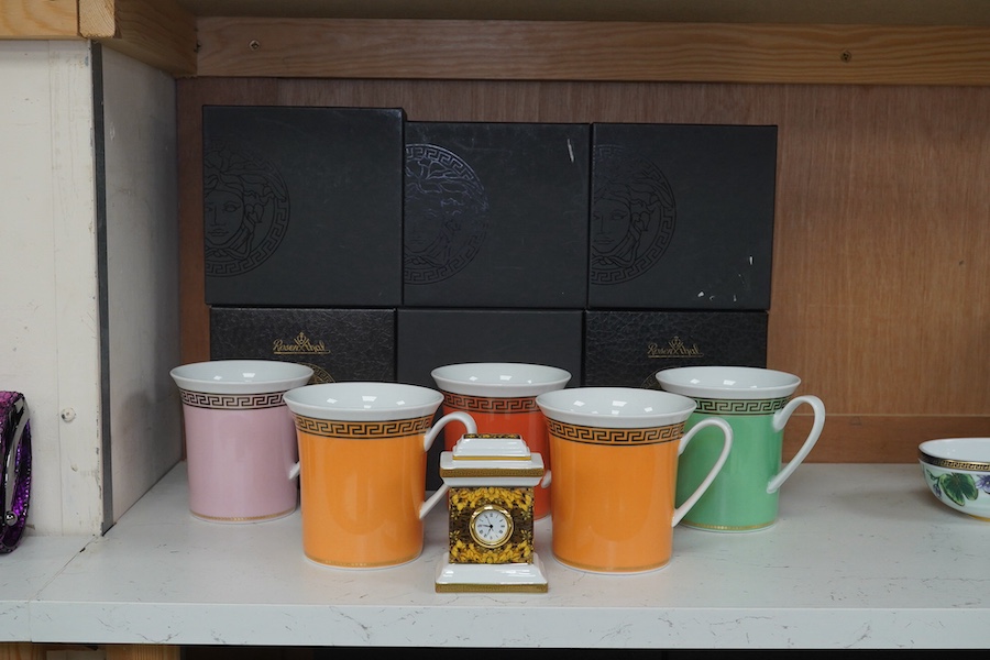 Five boxed Rosenthal for Versace mugs in various colours with Greek key pattern decoration together with a boxed miniature timepiece, 8.5cm high (6). Condition - good.